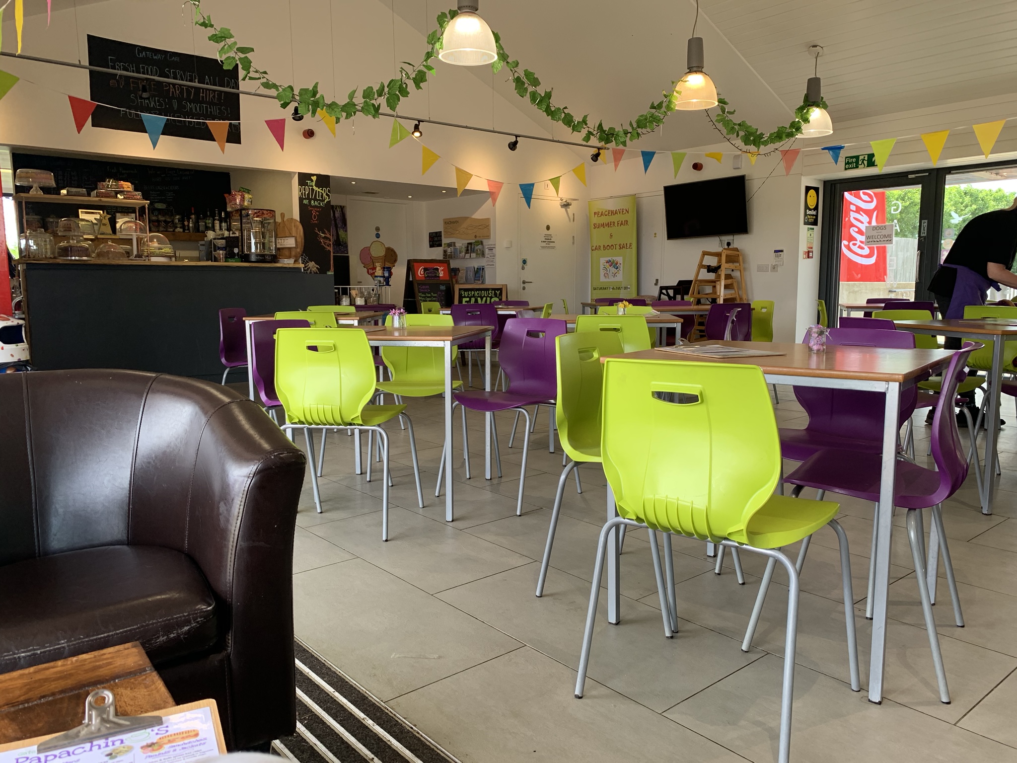 Inside Gateway Café, with colourful chairs, bunting and the café counter
